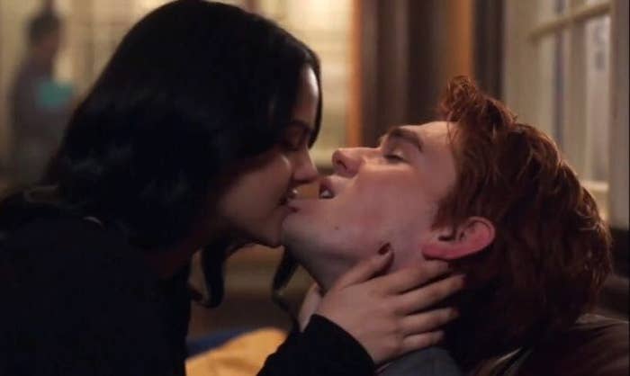 a character biting someone's lip as they make out