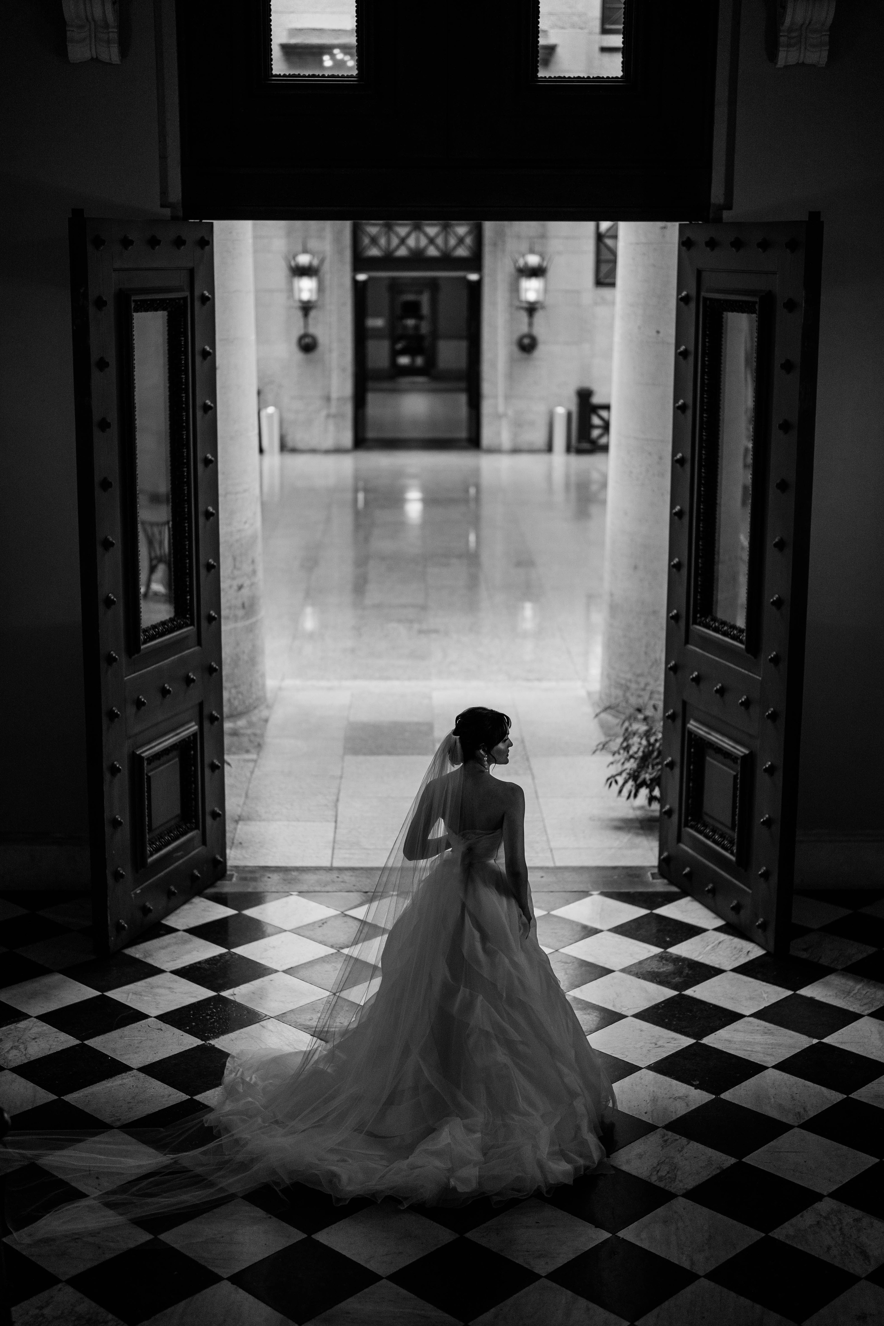 a bride stands in front of a doorway
