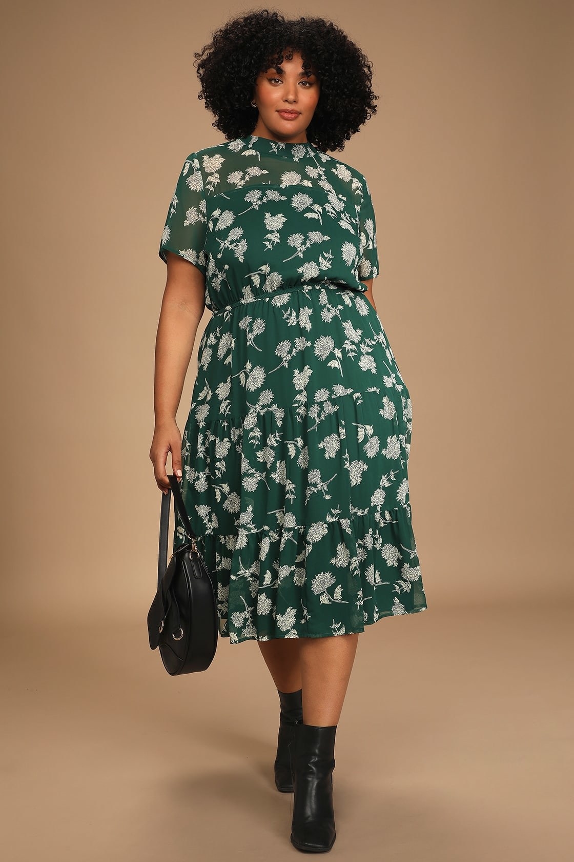 model in green and white floral midi dress with high mock neck, and short sleeves