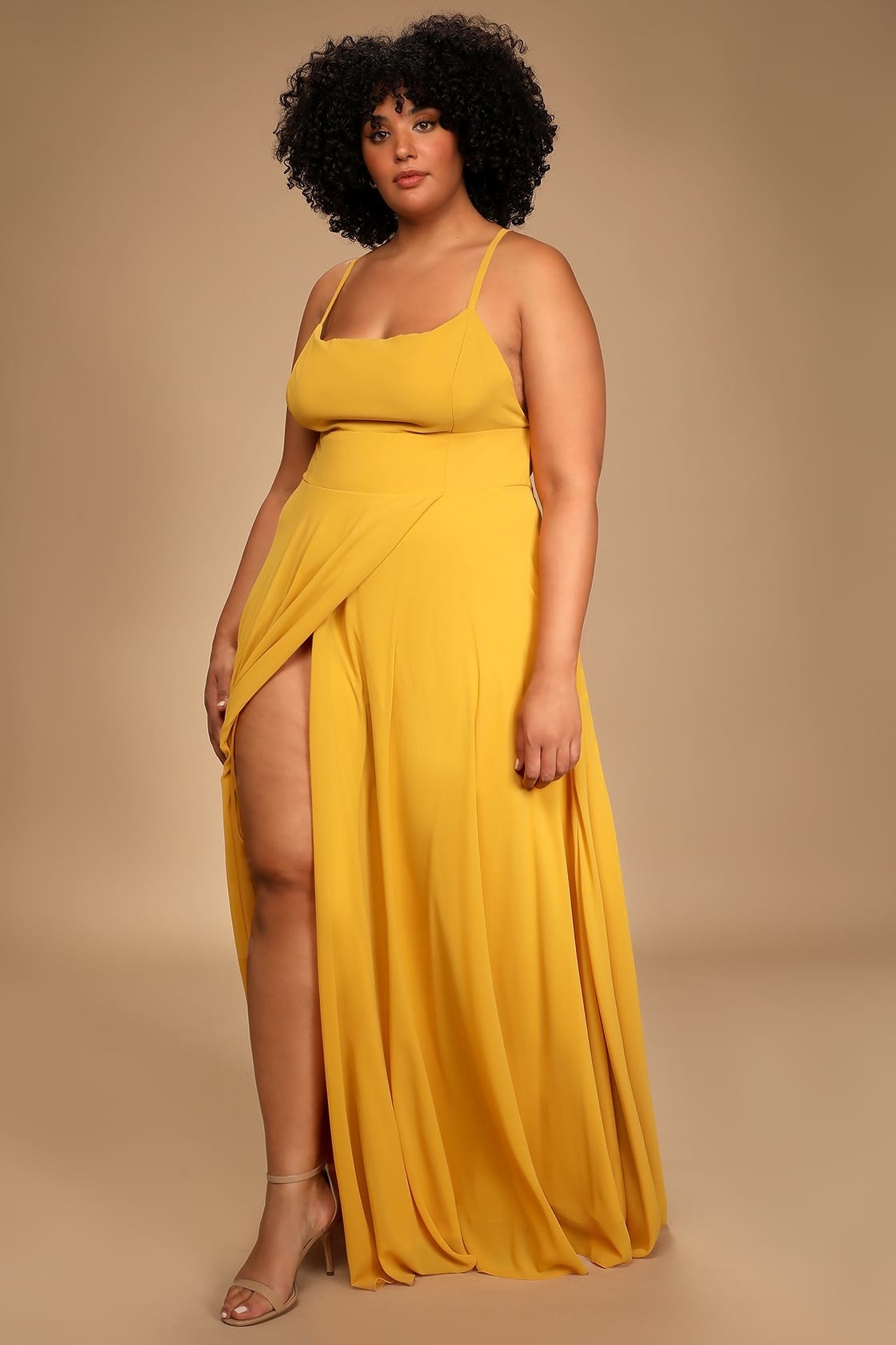 model in mustard yellow maxi dress with high leg slit and spaghetti straps