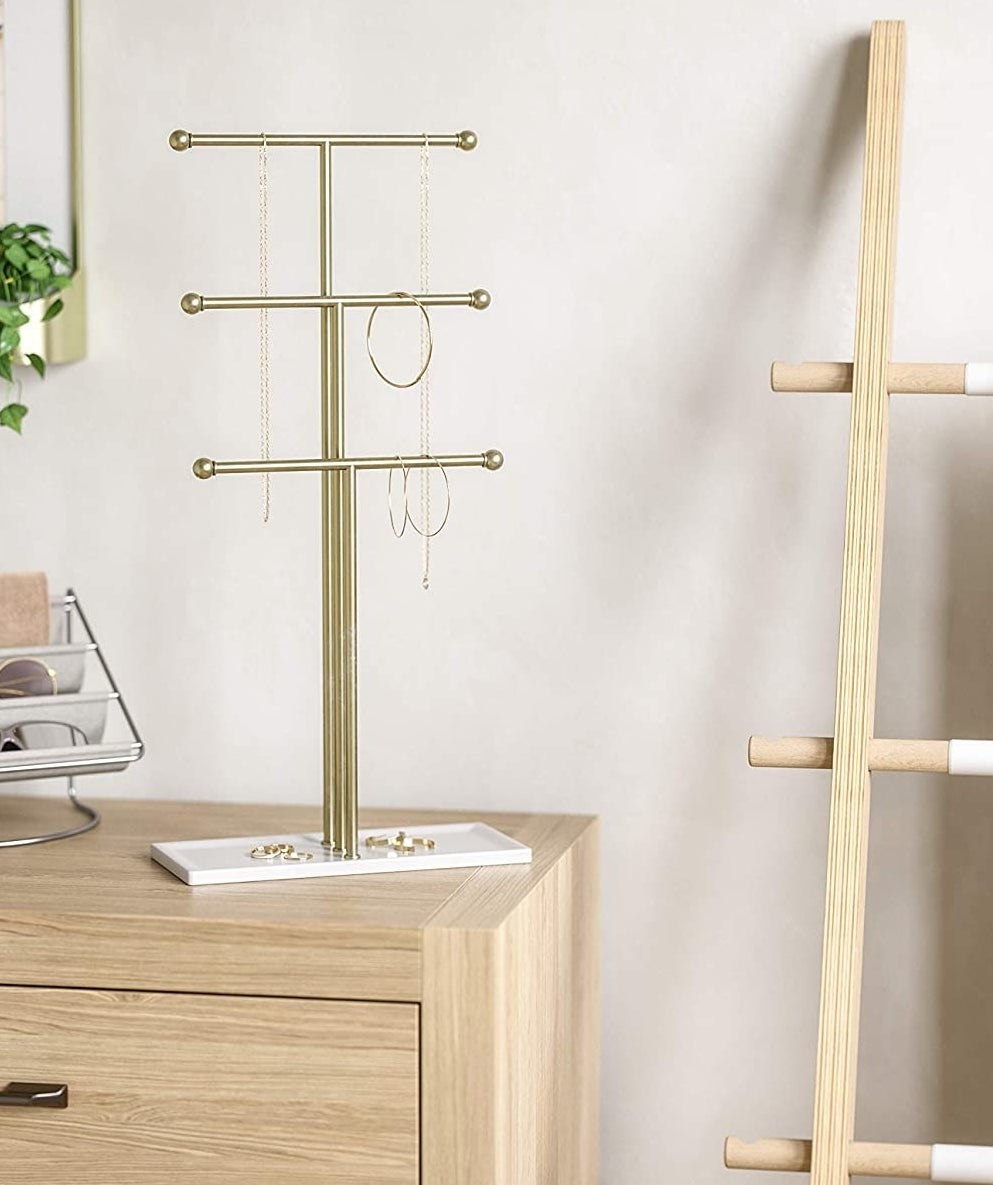 a jewellery stand on a dresser in a bedroom