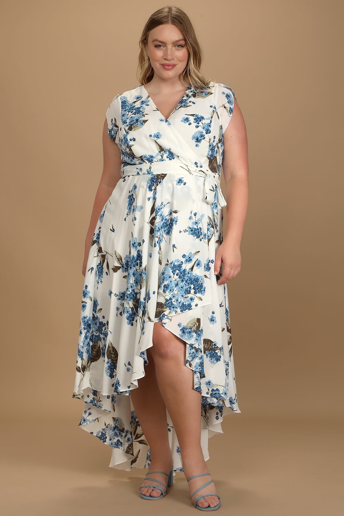 model in white maxi dress with a blue floral pattern, a high-low ruffled skirt, and a waist tie