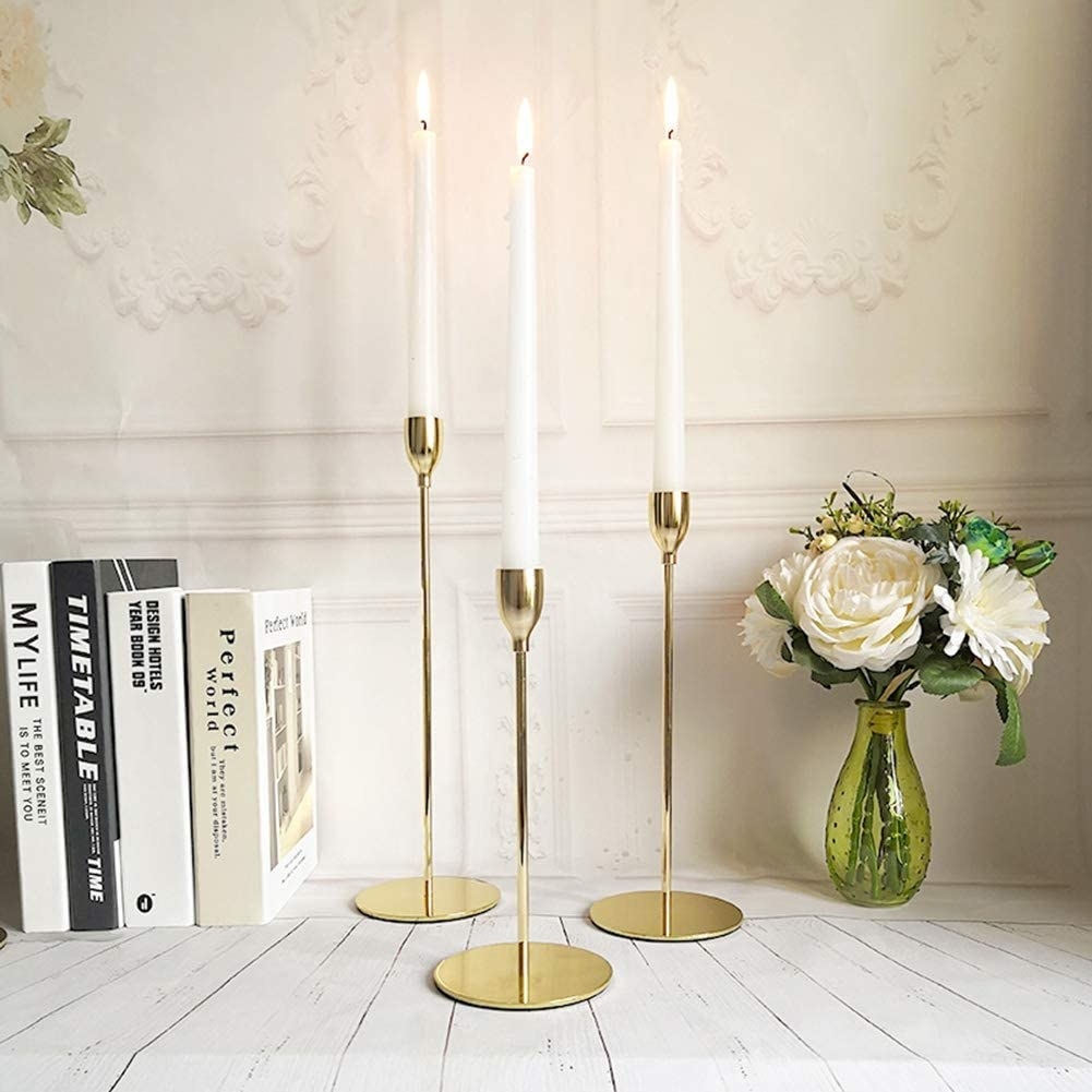 three candle holders with taper candles in each