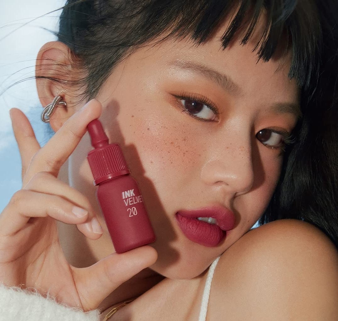 a model holding the lipstick bottle