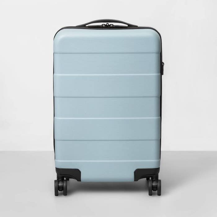 An image of a white hard side carryon spinner suitcase with expandable sides and multiple compartments