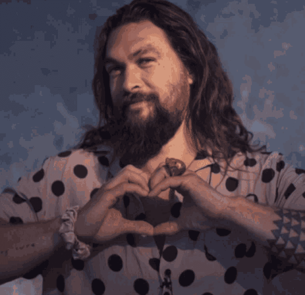 Jason Momoa making a heart with his hands and framing his face