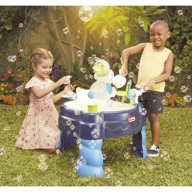 Children playing with the water table that gives out foam and bubbles