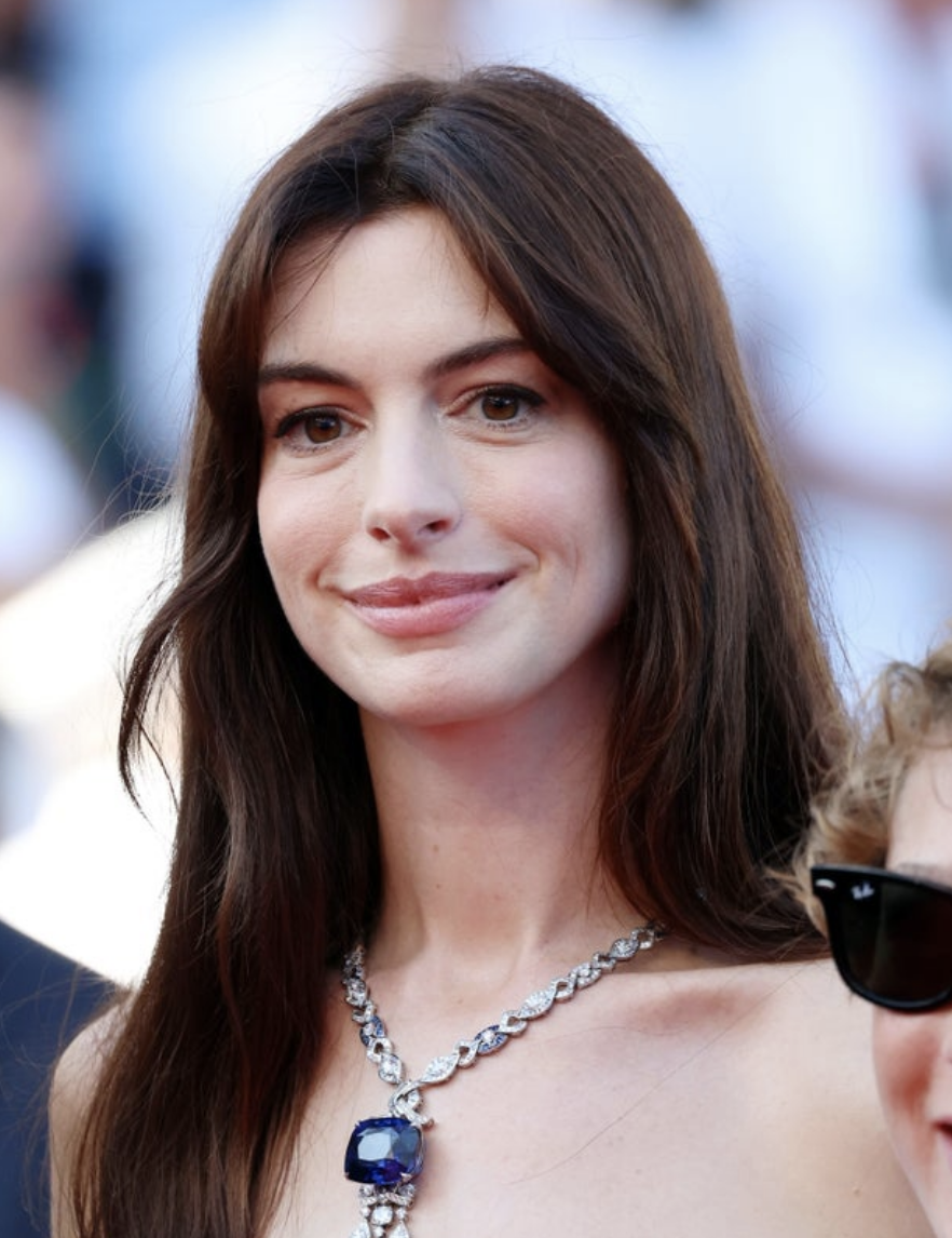 Anne in white with a giant necklace on the red carpet