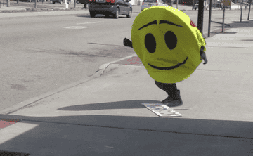 a person in a smily face suit falling down