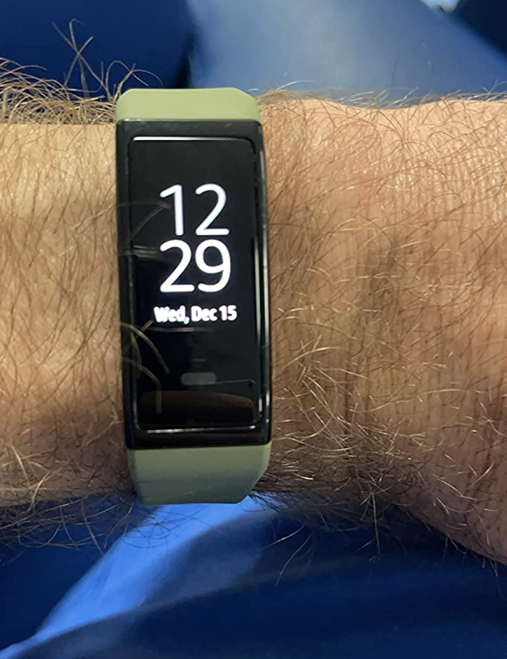 a reviewer wearing their fitness tracker in green