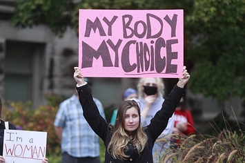 A demonstrator holds a sign that says "my body my choice"