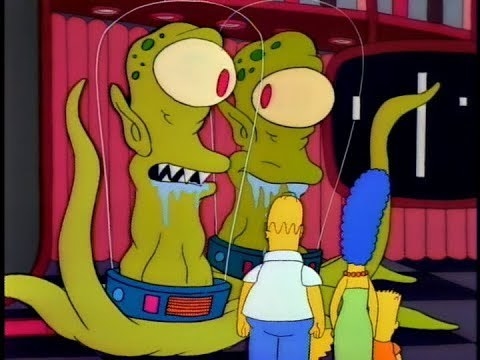 Two giant green aliens with glass domes over their heads stand in front of the Simpson family