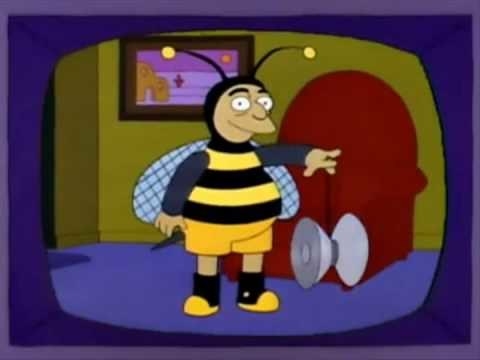 A TV showing a man dressed in a bumble bee outfit, playing with a giant yoyo