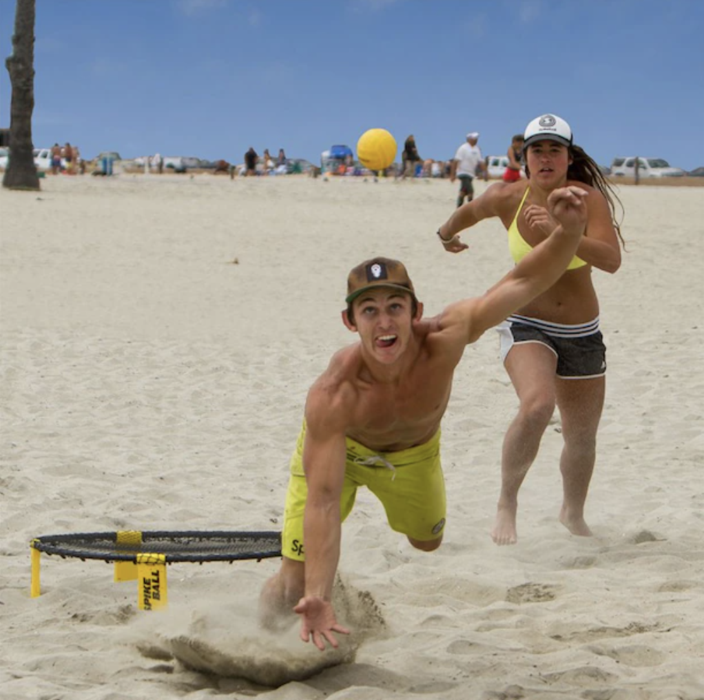 people playing spikeball on the beach