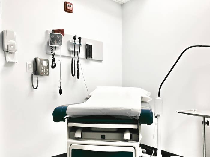 an empty exam room with paper over the bed ready to see a new patient