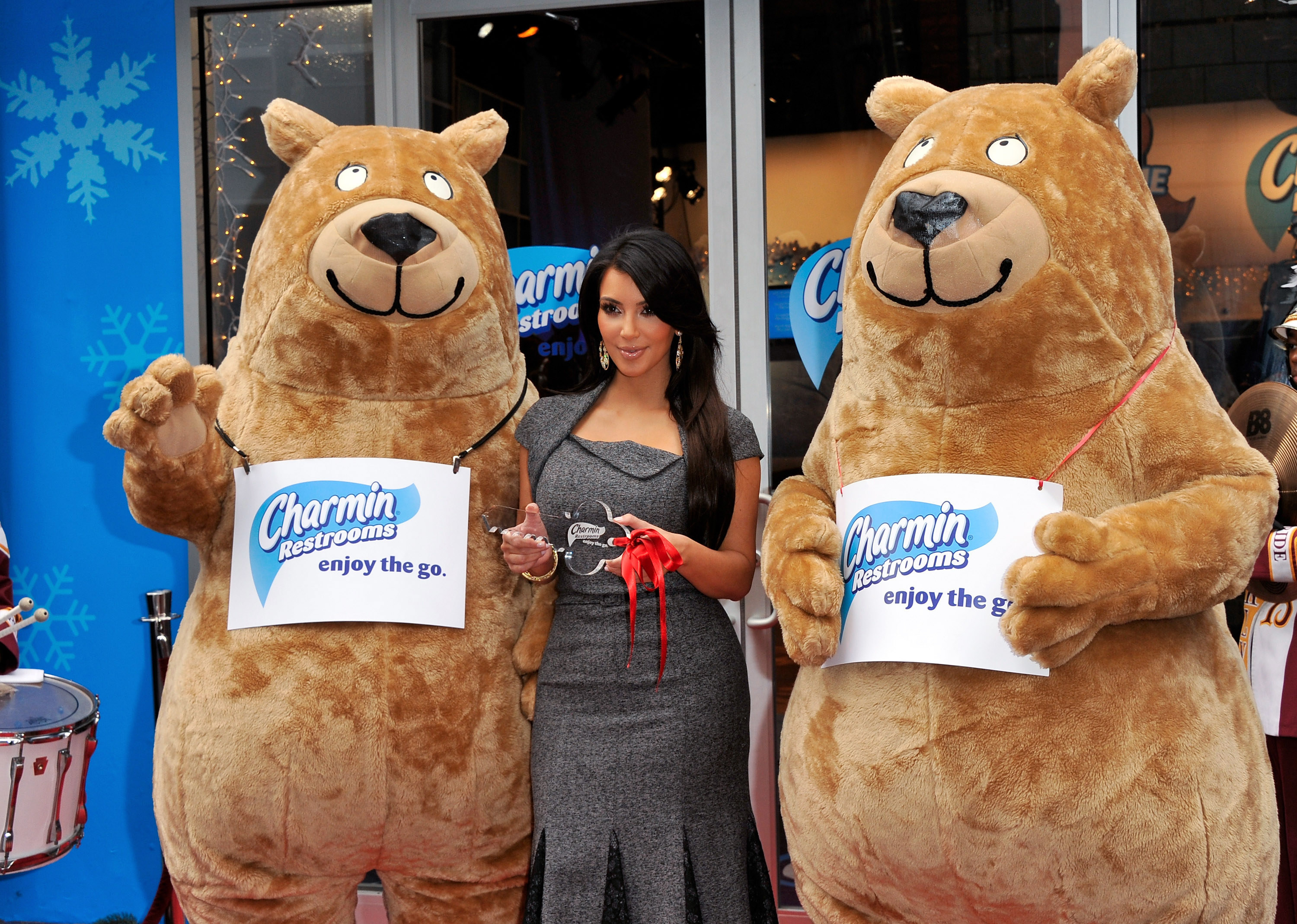 Kim stands between two large plush Charmin bears