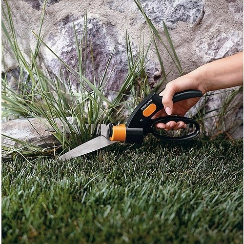 model using the shears to cut grass