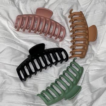 four claw clips sitting on a white comforter