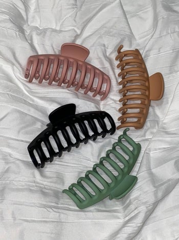 four claw clips sitting on a white comforter