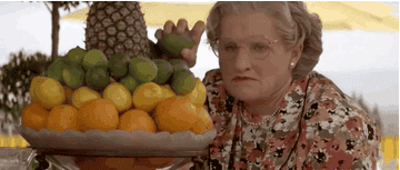 Robin Williams as Mrs Doubtfire throwing fruit at Pierce Brosnan as Stuart