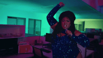 GIF of Lizzo dancing and singing in an empty office from the music video of &quot;About Damn Time.&quot;