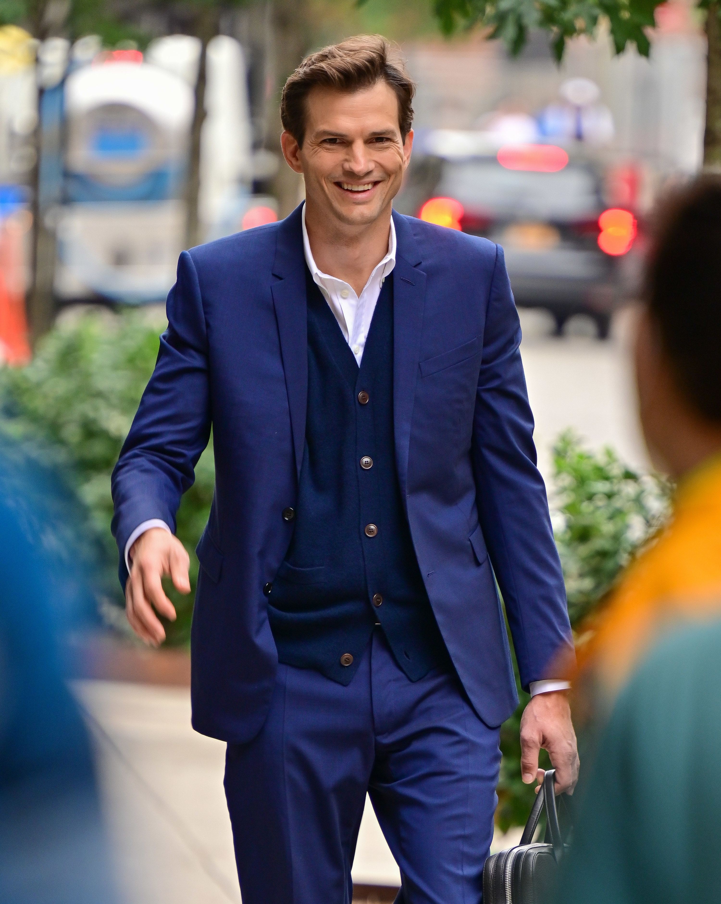 Ashton Kutcher in a suit walking
