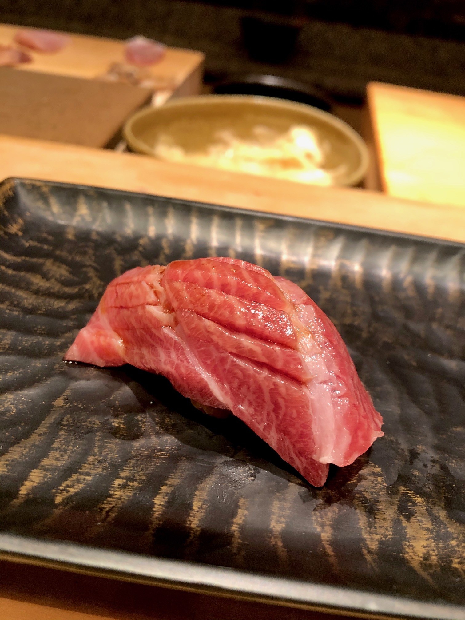 A piece of tuna sushi on a plate.
