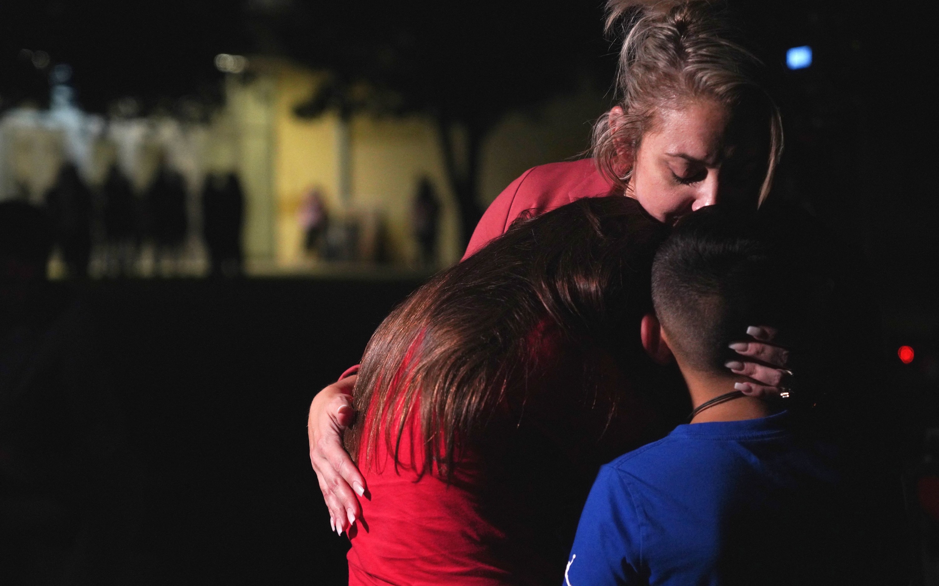 A mother holds two children close