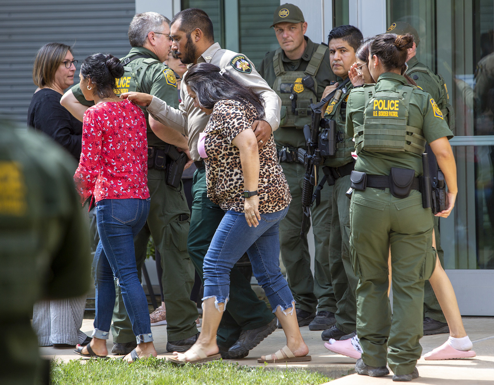 Citizens and Border Patrol agents stand outside