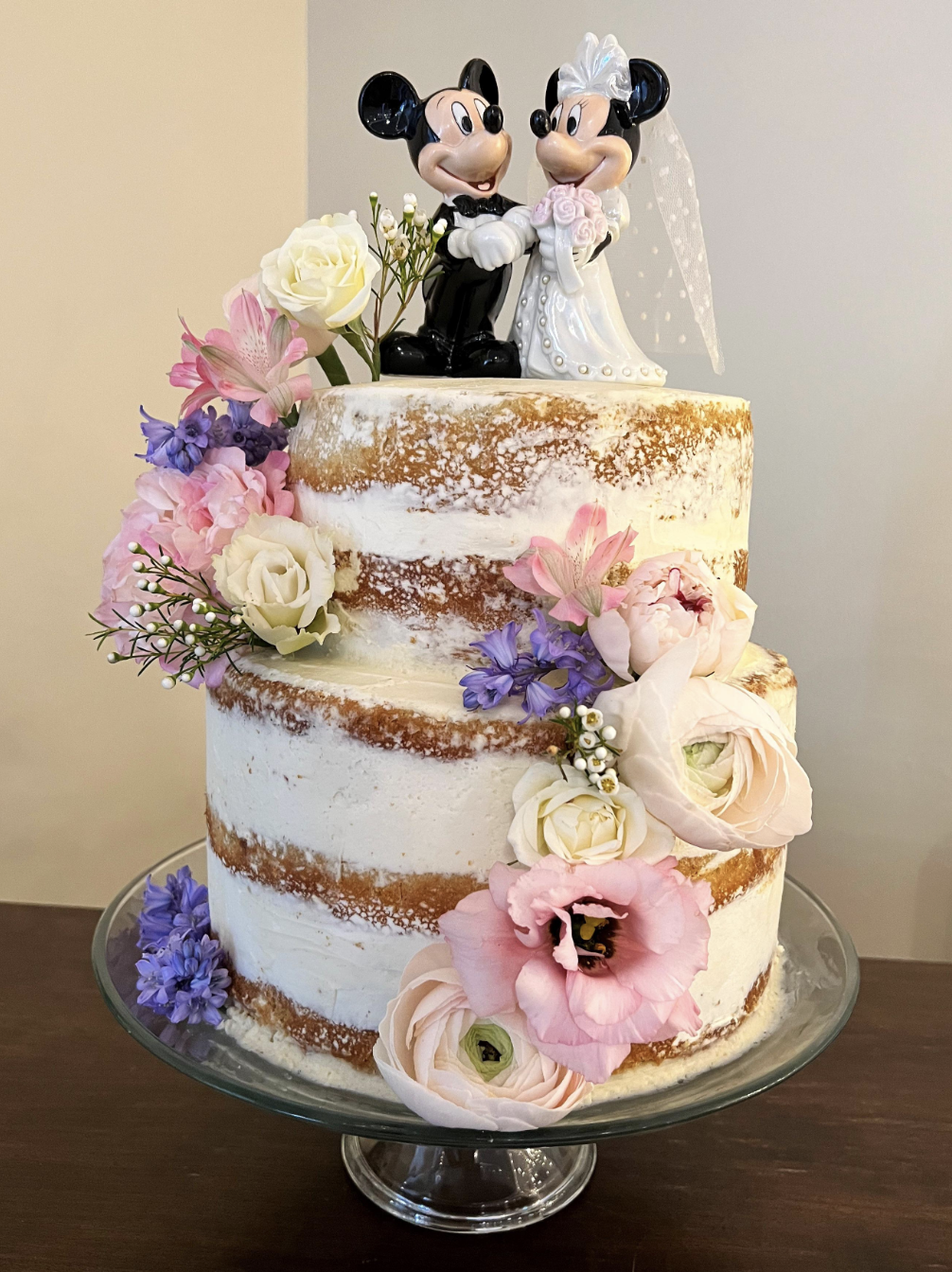 A wedding cake with Mickey and Minnie as cake toppers