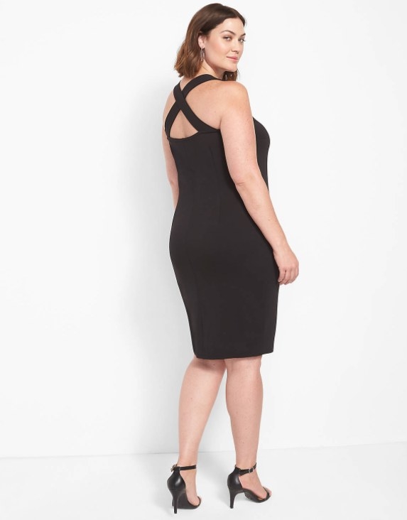 In image of a model wearing a black bodycon LBD with crisscross straps at the back
