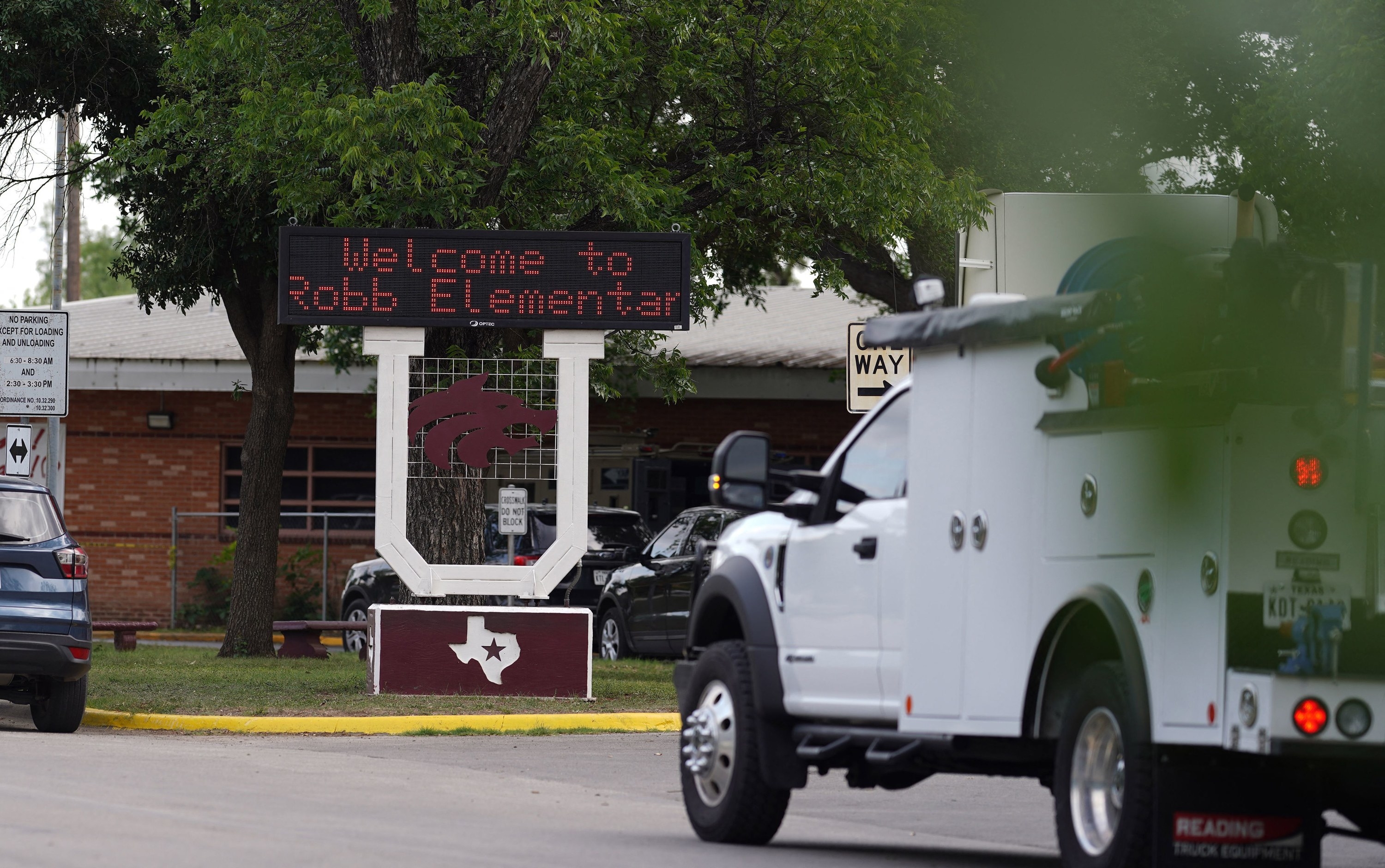 An electronic sign outside reads &quot;Welcome to Robb Elementary&quot; over a large wooden U and a placard of the state of Texas with a star in the middle