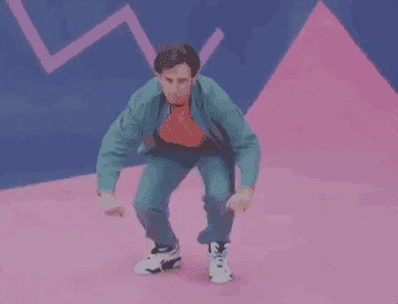 Kyle Mooney dancing in 80s-themed pastel clothes
