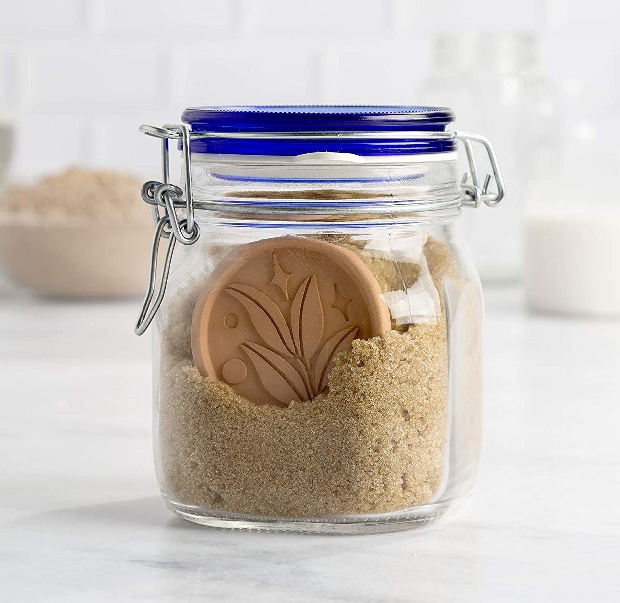 a jar of brown sugar with one of the terracotta discs visible inside
