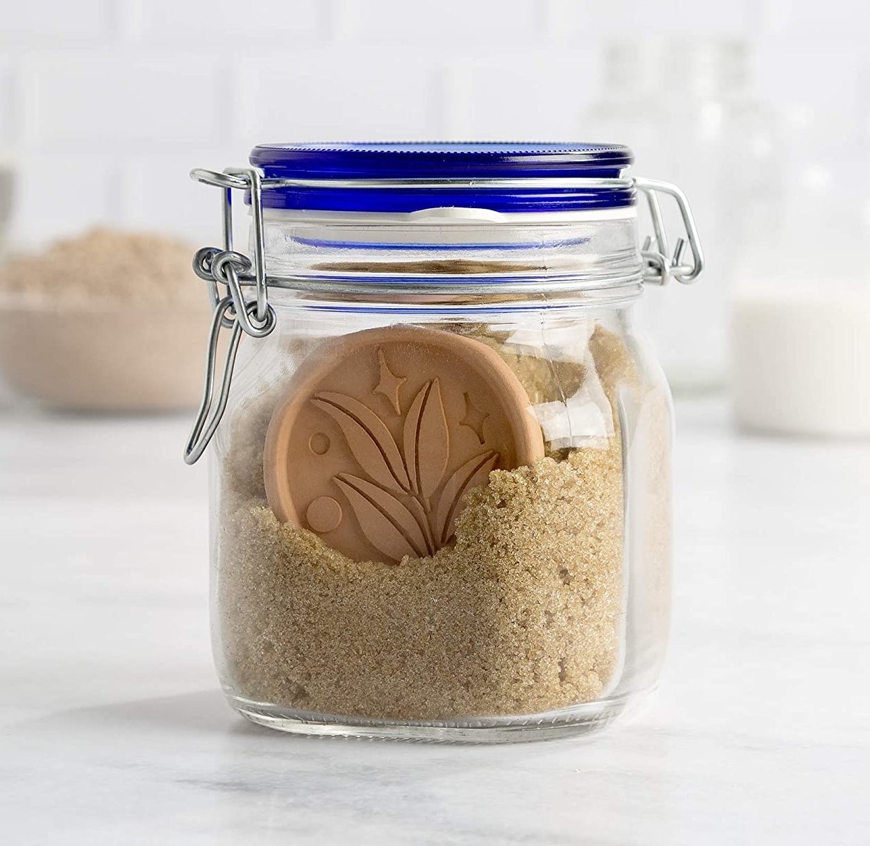 a jar of brown sugar with one of the terracotta discs visible inside
