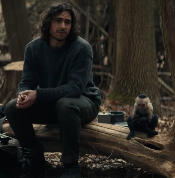 Ben Schnetzer as Yorick sitting on a log with his pet monkey Ampersand