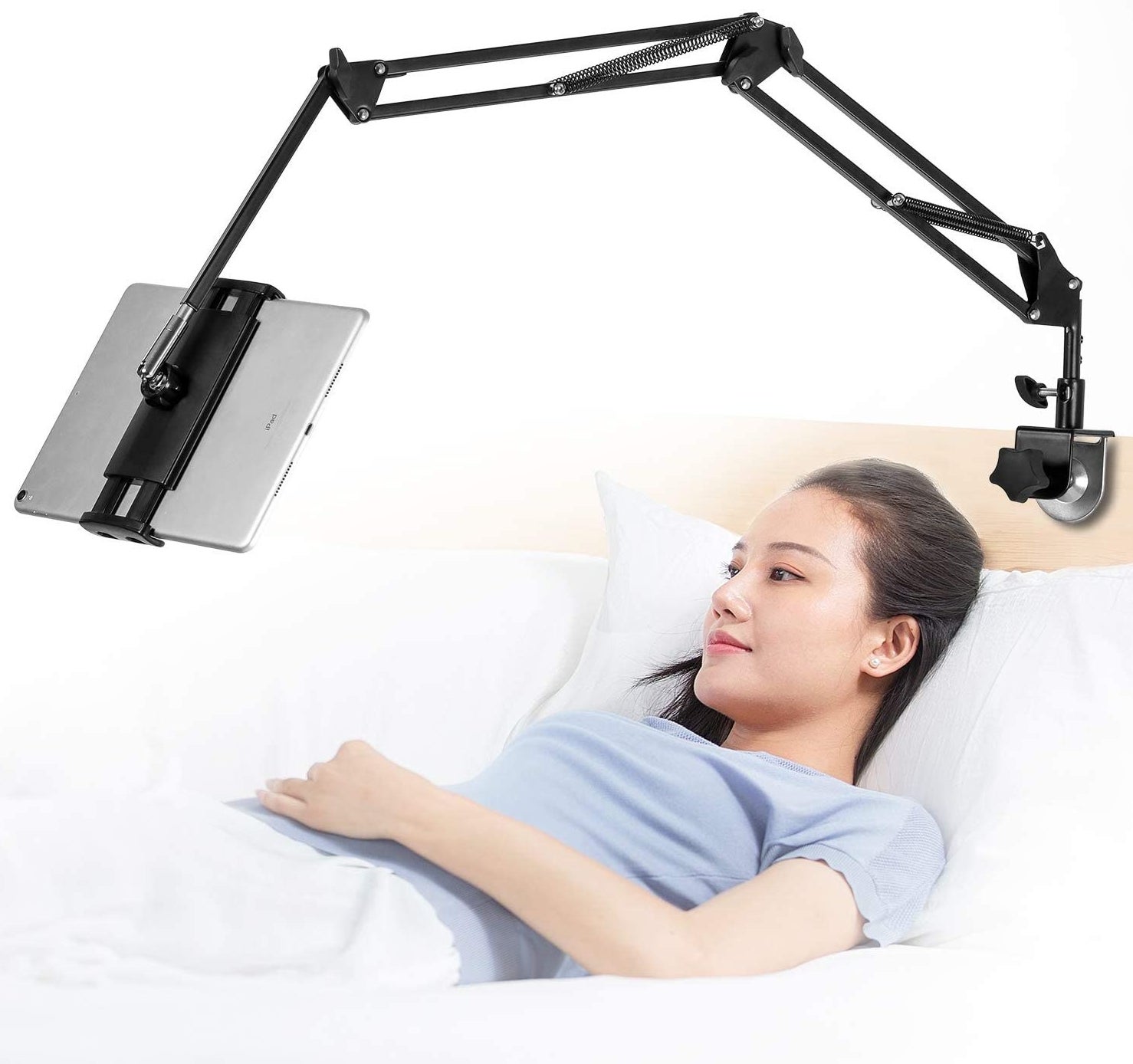 someone laying in bed with their tablet suspended overhead