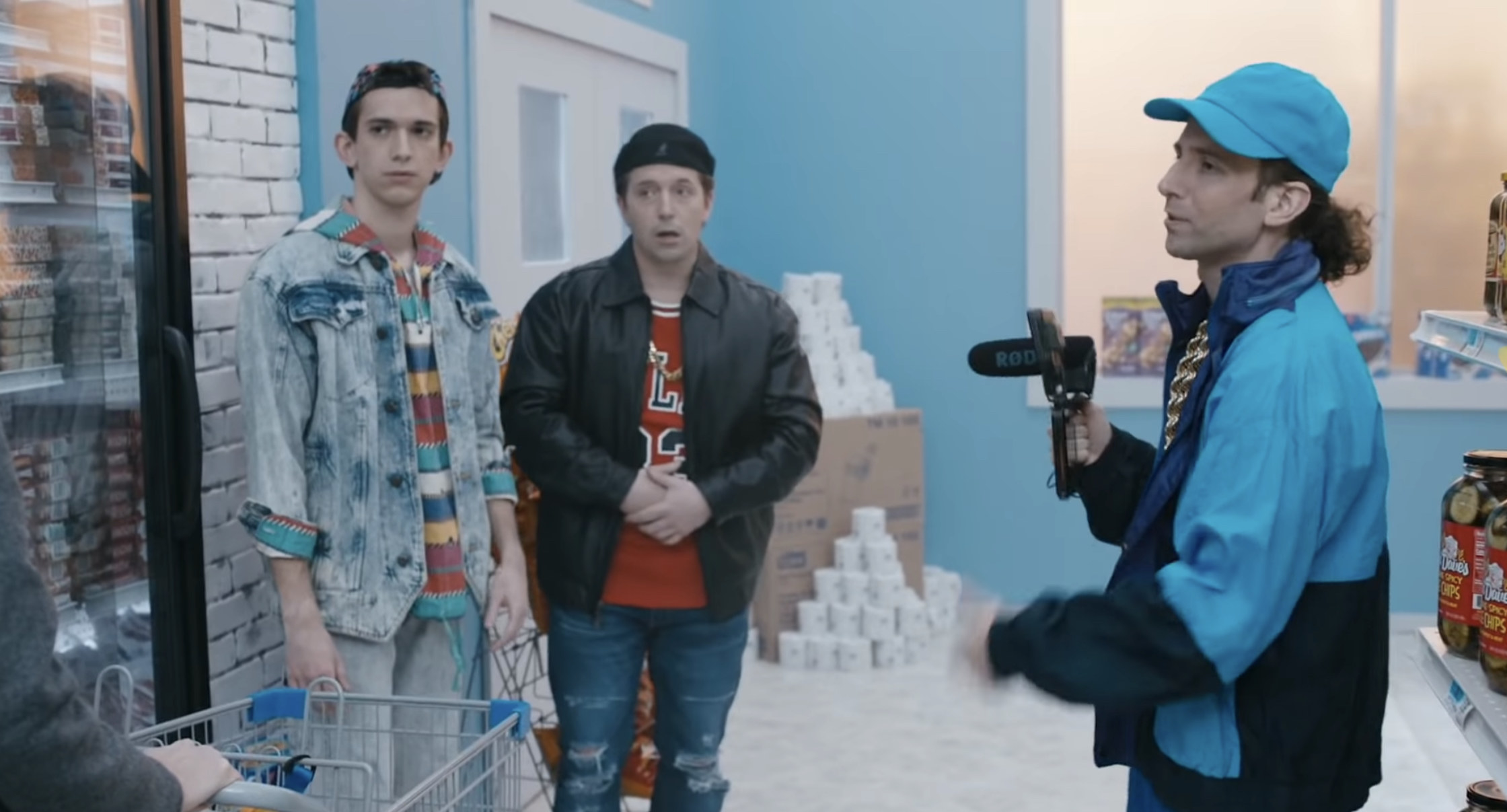 Kyle Mooney, Beck Bennett, and Andrew Dismukes stand in a grocery store wearing 80s-era hip hop clothes