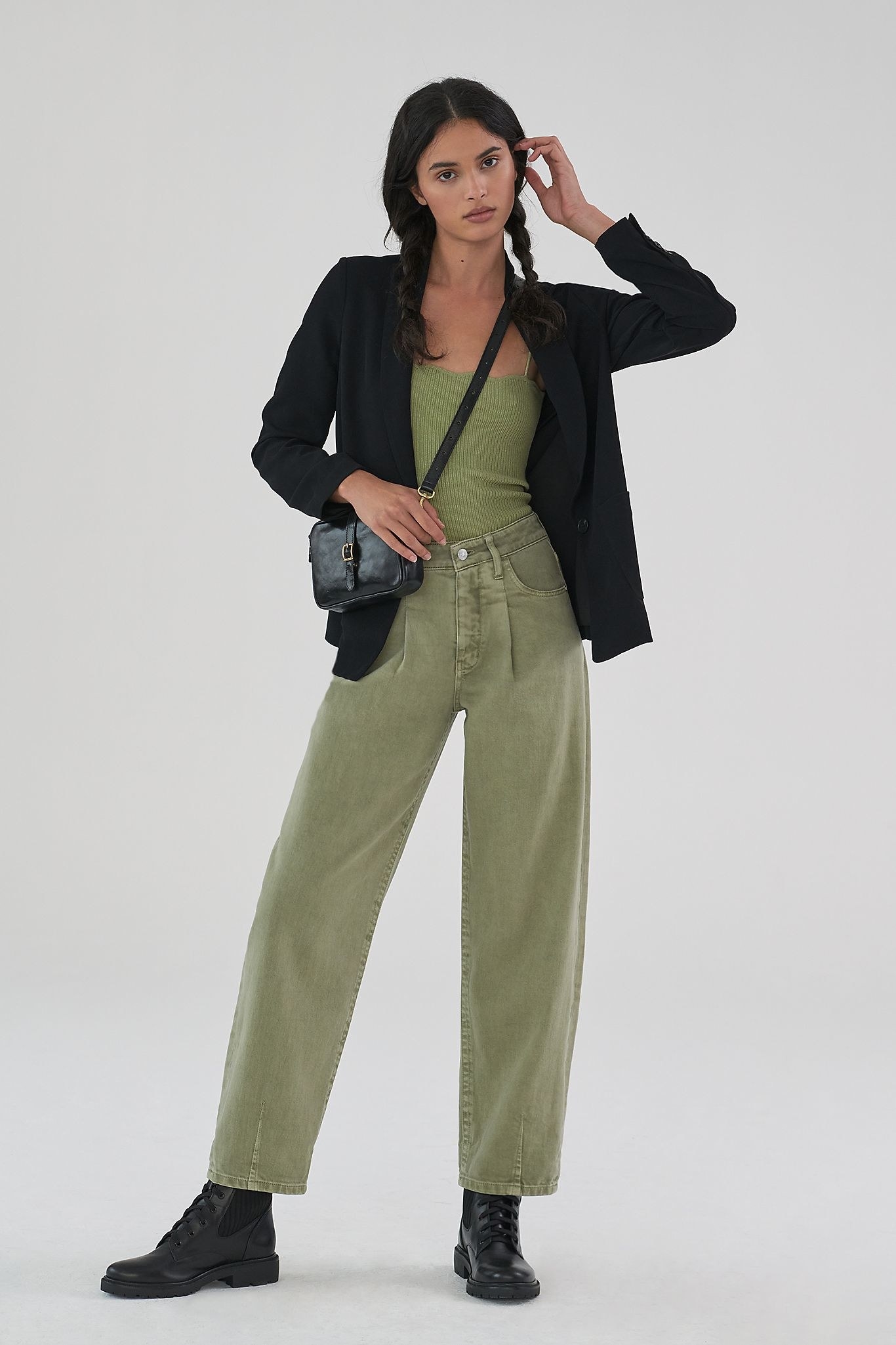 Model wearing relaxed fit high-rise green jeans with matching green tank and black blazer