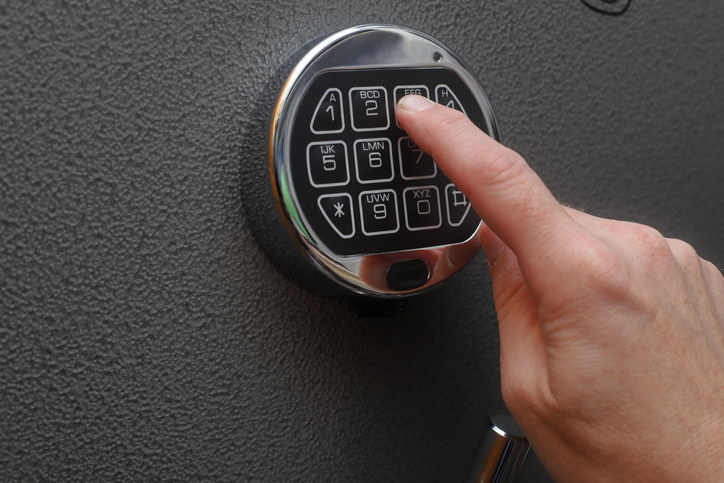 A person entering the code to a safe