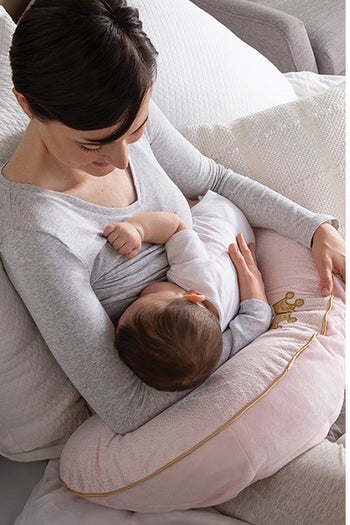 A model feeding baby on the pillow