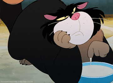 a cartoon cat dipping his paw in some milk
