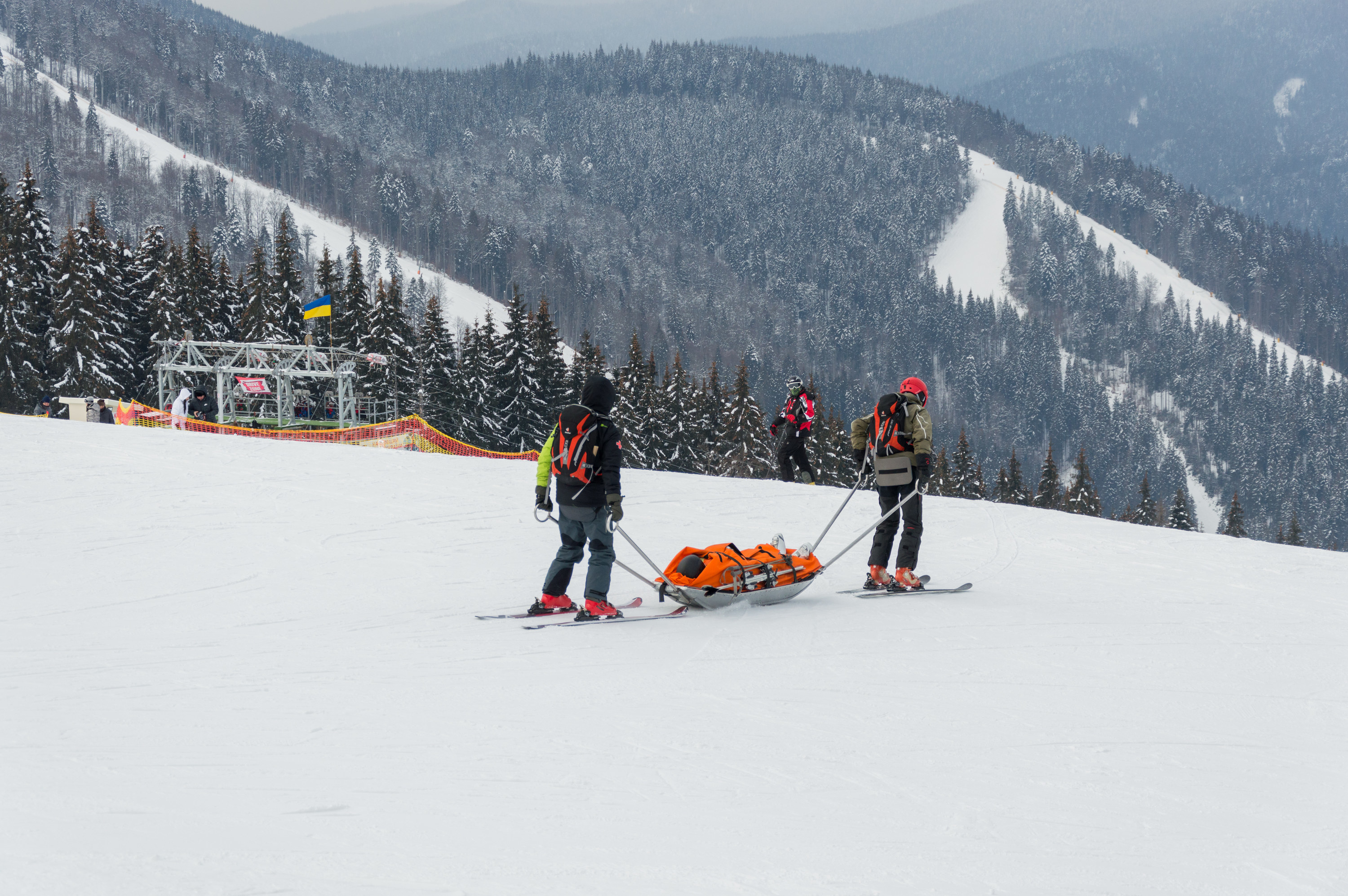 Ski patrol team rescue injured skier with the special emergency sledges in the Carpathian mountains region