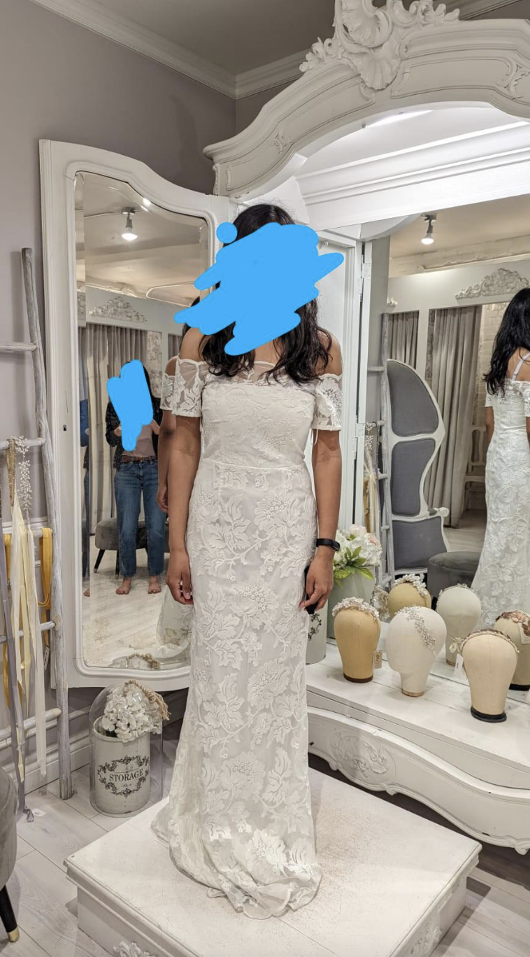 A woman with her face blurred wearing a wedding dress