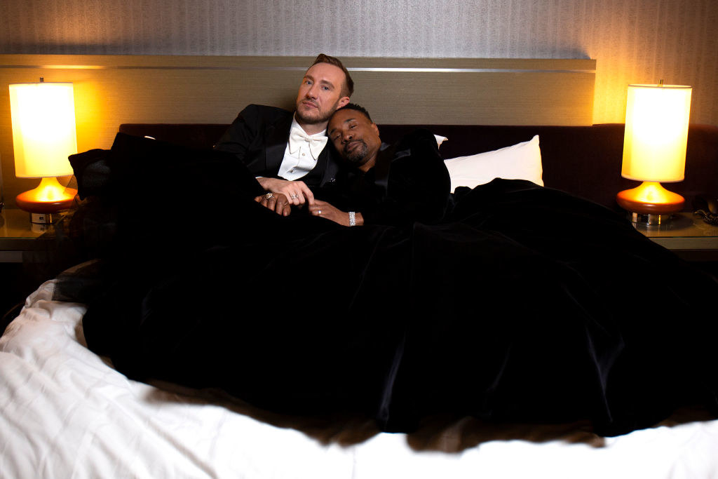 Billy and Adam cuddling on a red in red carpet attire