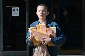 Eleven from Stranger Things holding boxes of Eggo waffles