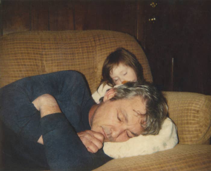 a dad asleep on his kid daughters lap who is also asleep