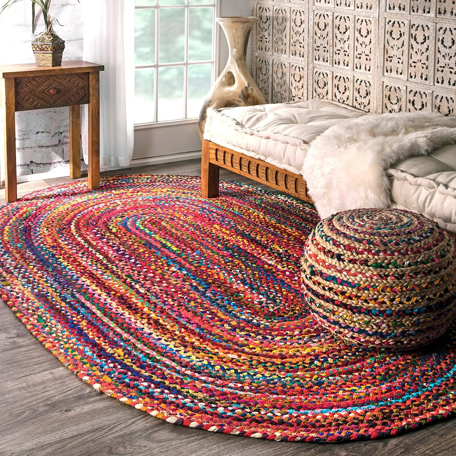 the rug in a living space under a pouf and couch