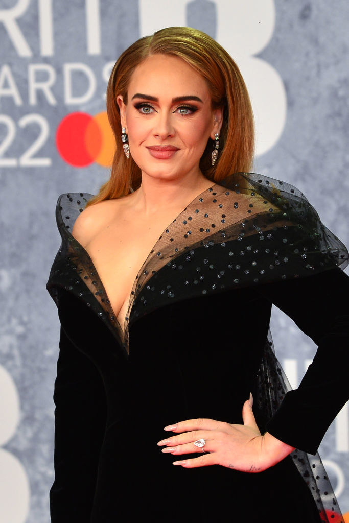 Adele in a deep plunge dress with hair parted to the side