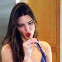 GIF of Kendall sucking on a lollipop and touching her hair